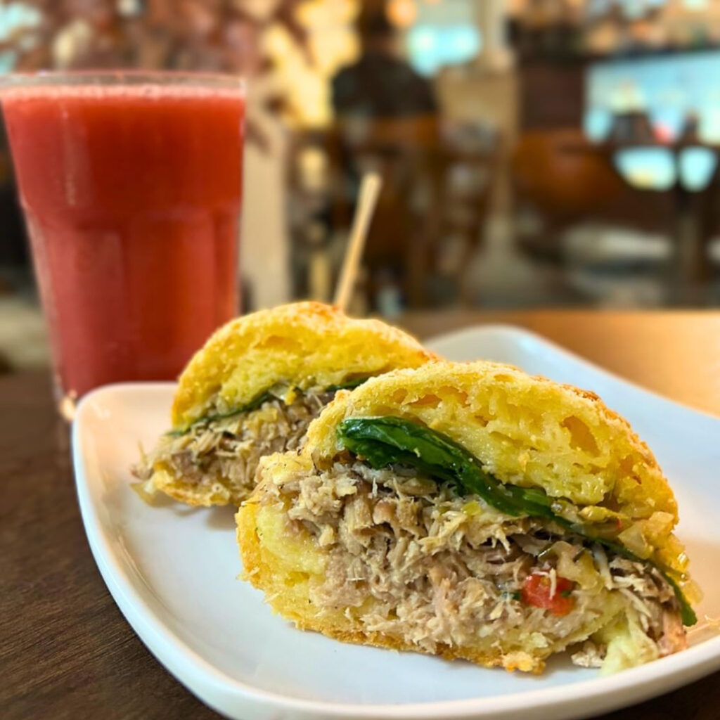 Pão de Queijo Colonial recheado com pernil desfiado, rúcula, e salsa mogiana